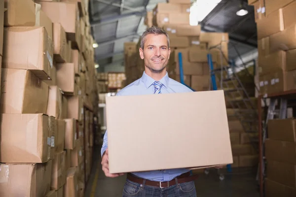 Worker carrying box in warehouse — Stock Photo, Image