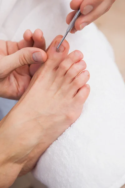 Pedicurist cleaning customers toe nails — Stock Photo, Image