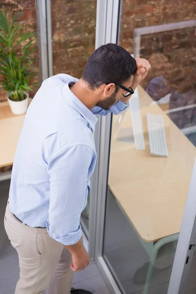 Businessman standing against glass wall — Stock Photo, Image