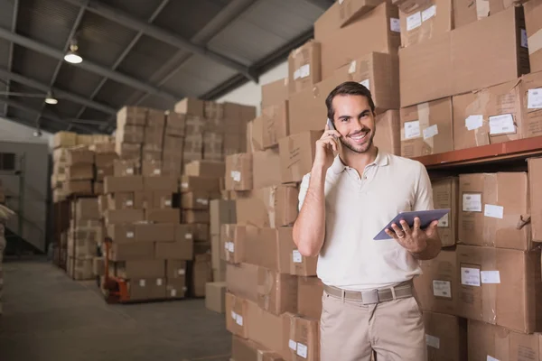 Trabajador con teléfono móvil y tableta digital — Foto de Stock