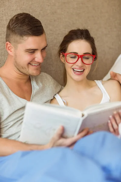 Пара читає книгу в ліжку — стокове фото
