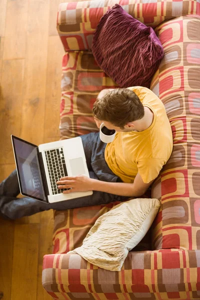 Mann benutzt Laptop auf Couch — Stockfoto