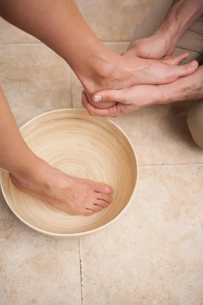 Pedicurista lavando pies femeninos — Foto de Stock