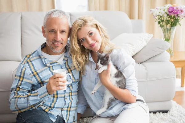 Pareja con gatito en el suelo — Foto de Stock