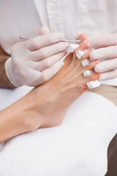 Fußpflegerin reinigt Kunden Fußnägel — Stockfoto
