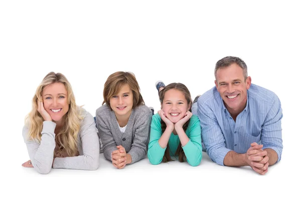 Famiglia sdraiata sul pavimento sorridente alla macchina fotografica — Foto Stock