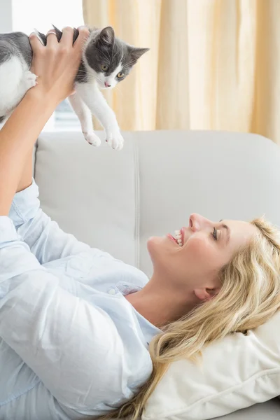 Mujer con gatito en sofá — Foto de Stock