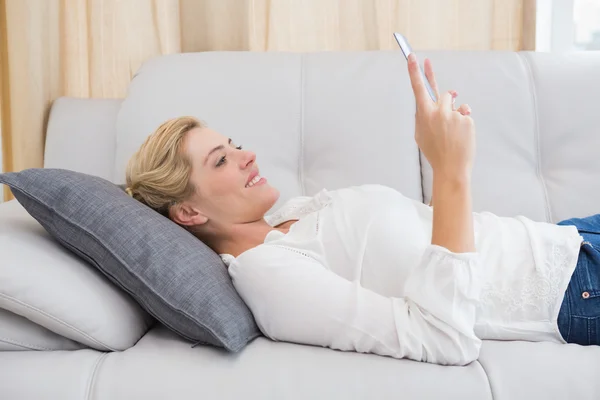 Kobieta przy użyciu komputera typu tablet na kanapie — Zdjęcie stockowe