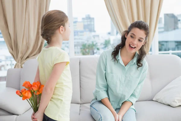 Chica ocultando flores de madre —  Fotos de Stock