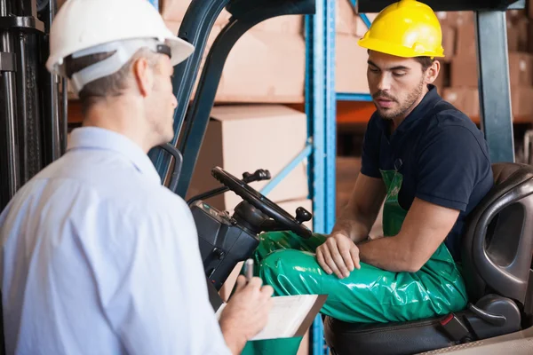 Gerente hablando con el conductor de la carretilla elevadora — Foto de Stock