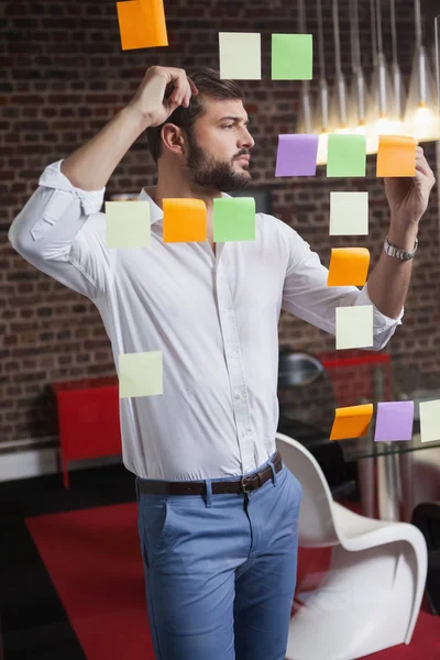 Businessman writing on sticky notes — Stock Photo, Image