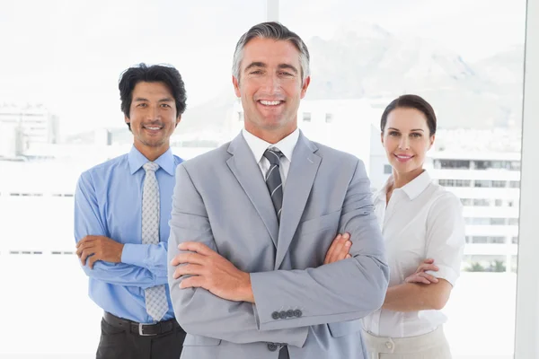 Equipo de negocios de pie con los brazos cruzados — Foto de Stock