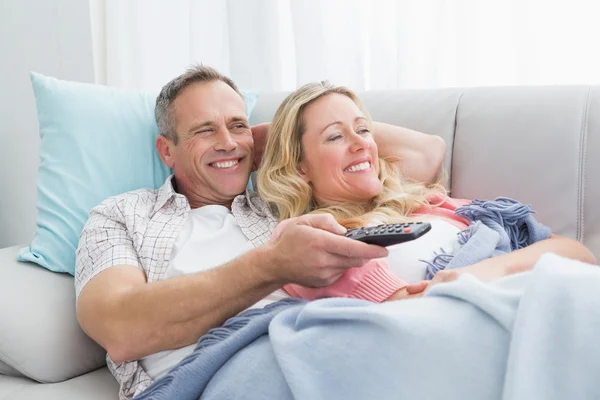 Para przytulanie na kanapie oglądając telewizor — Zdjęcie stockowe