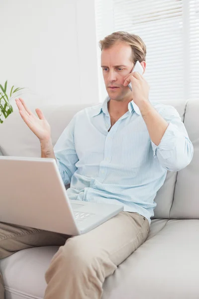 Homem usando laptop no sofá — Fotografia de Stock