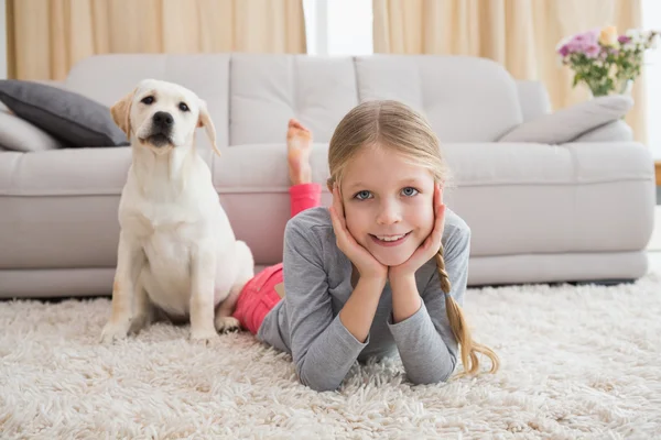 Meisje met puppy op tapijt — Stockfoto
