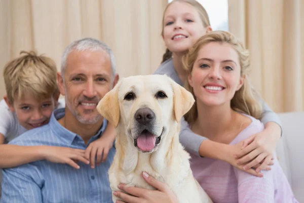 Eltern und Kinder auf dem Sofa mit Labrador — Stockfoto