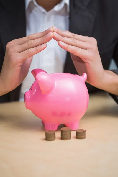 Zakenman overhandigt piggy bank — Stockfoto