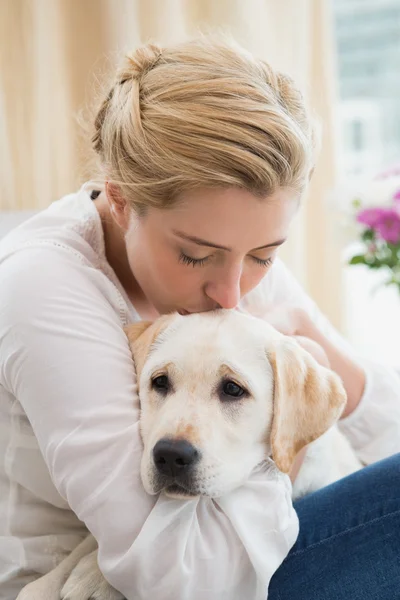 Mujer abrazo con cachorro en sofá — Foto de Stock