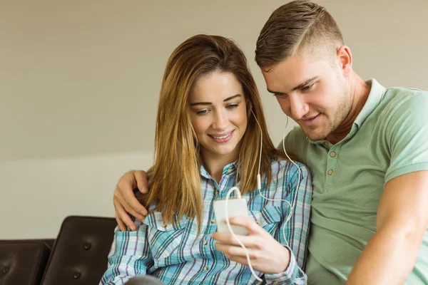 Couple relaxing on couch with smartphone — Stock Photo, Image