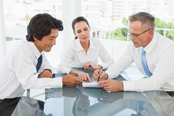 Business team looking over notes — Stock Photo, Image