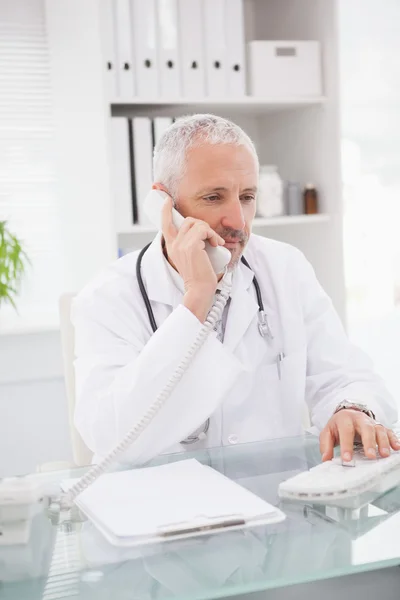 Doctor phoning and using computer — Stock Photo, Image