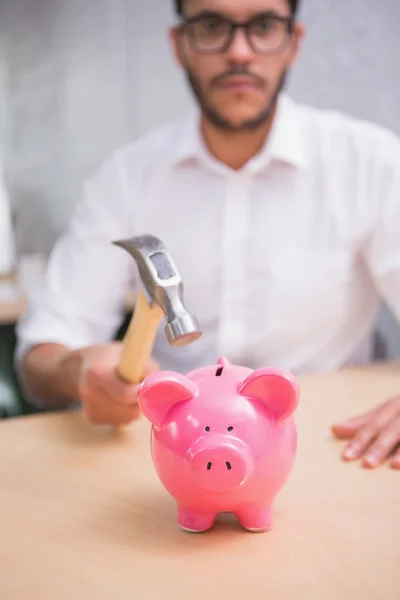 Hombre de negocios rompiendo hucha — Foto de Stock