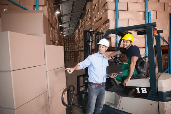 Manager praten met heftruck chauffeur — Stockfoto