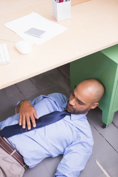 Επιχειρηματίας που κοιμάται κάτω από την επιφάνεια εργασίας — Φωτογραφία Αρχείου