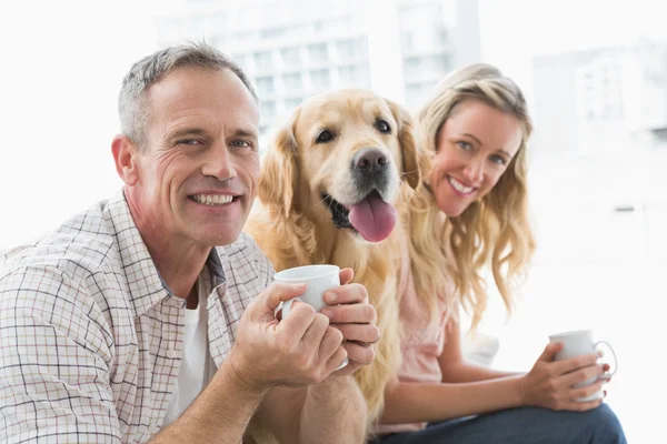 Pareja sentada en sofá tomando café — Foto de Stock