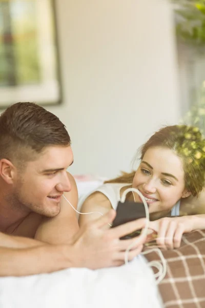 Couple couché sur le lit écouter de la musique — Photo