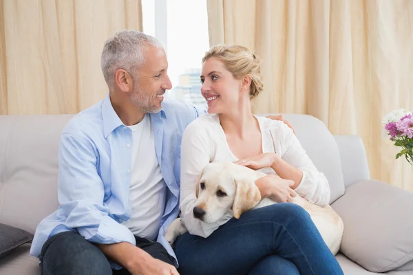 Coppia coccole con cucciolo sul divano — Foto Stock