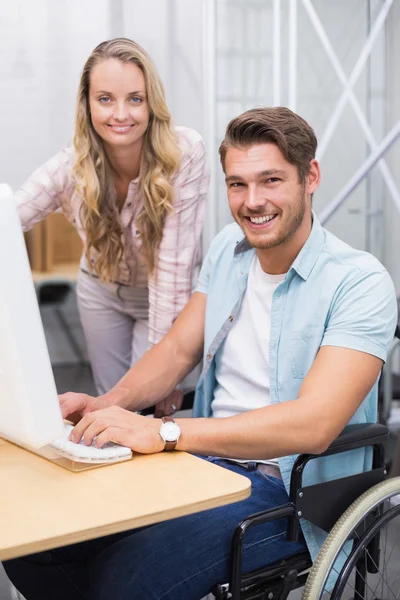 Businesswoman helping colleague in wheelchair — Stock Photo, Image