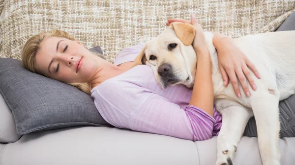 Piękna blondynka na kanapie z pies — Zdjęcie stockowe
