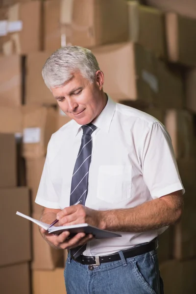 Manager mit Tagebuch im Lager — Stockfoto