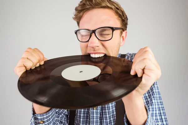 Hipster mordendo disco de vinil — Fotografia de Stock