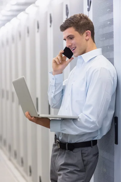 Technicus bellen en laptop gebruiken — Stockfoto