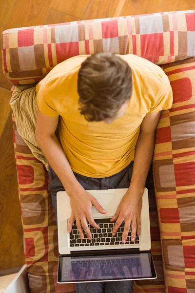 Man using laptop on couch — Stock Photo, Image