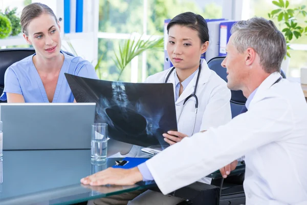 Medical team looking at x-ray during a meeting — Stock Photo, Image