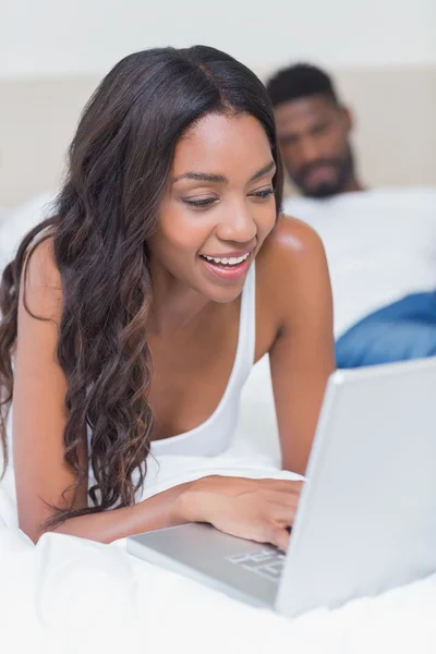 Femme détendue utilisant un ordinateur portable sur le lit — Photo