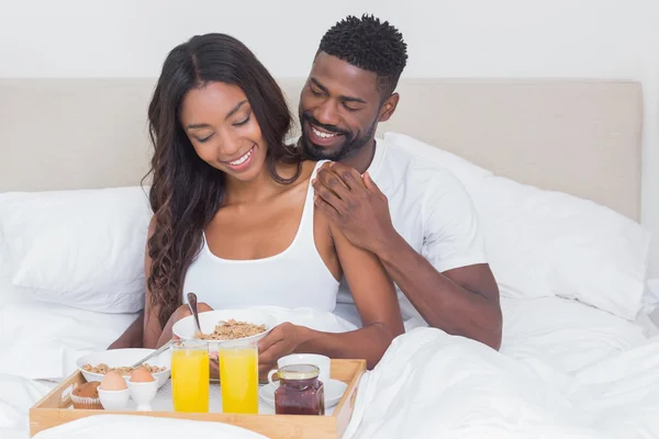 Casal relaxado tomando café da manhã na cama juntos — Fotografia de Stock