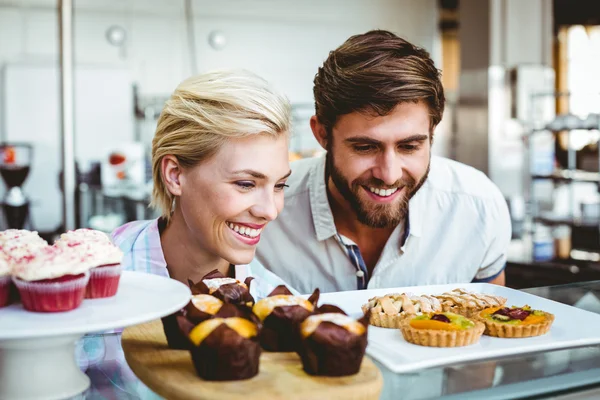 Linda pareja en una cita mirando pasteles — Foto de Stock