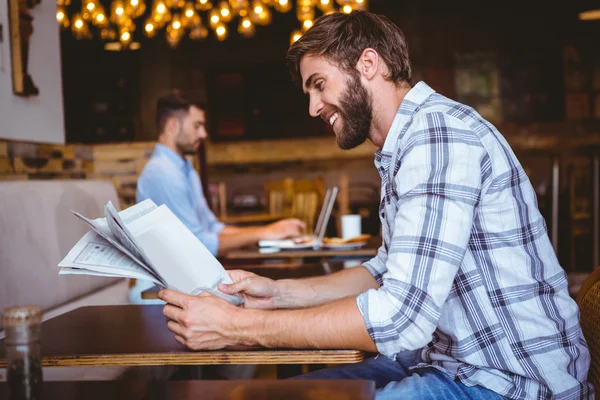 Jonge man die een krant leest — Stockfoto