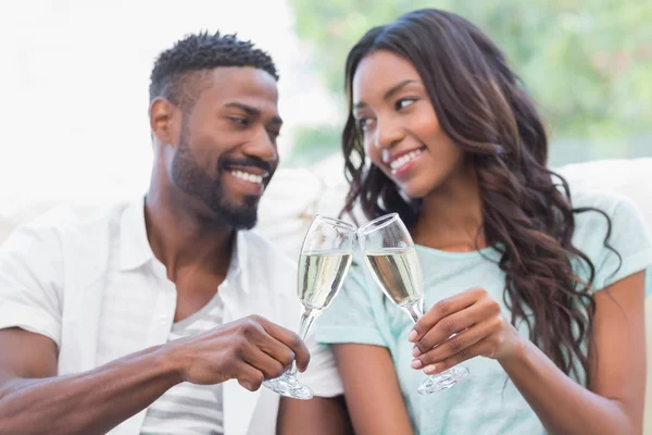 Casal no sofá tomando champanhe — Fotografia de Stock