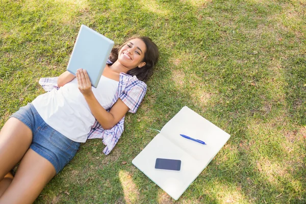 Brunette ontspannen in gras en lezen van boek — Stockfoto