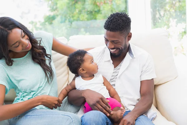 Couple with their baby girl on couch — Stock Photo, Image