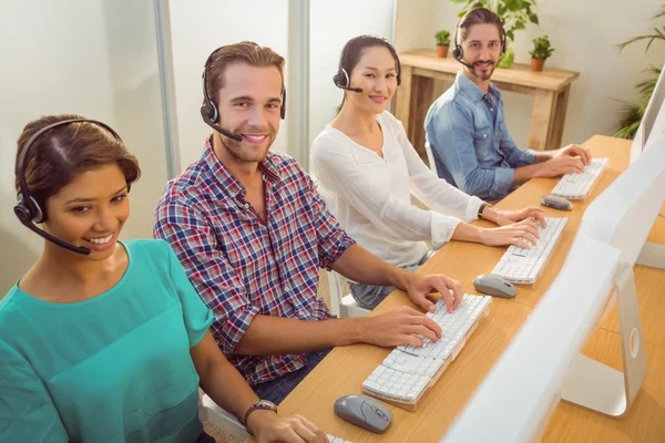 Lächelndes Callcenter-Team blickt in die Kamera — Stockfoto