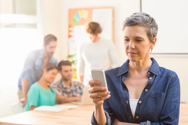 Casual businesswoman using her smartphone — Stock Photo, Image