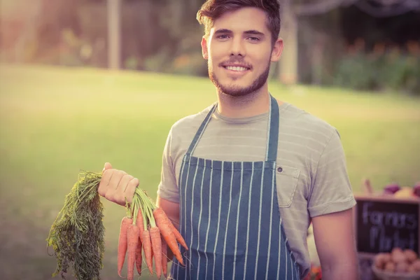Красивий фермер тримає моркву — стокове фото