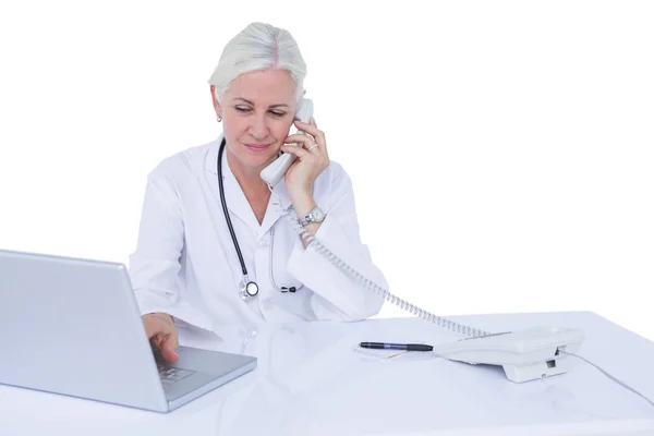 Doctor working on laptop and on phone — Stock Photo, Image