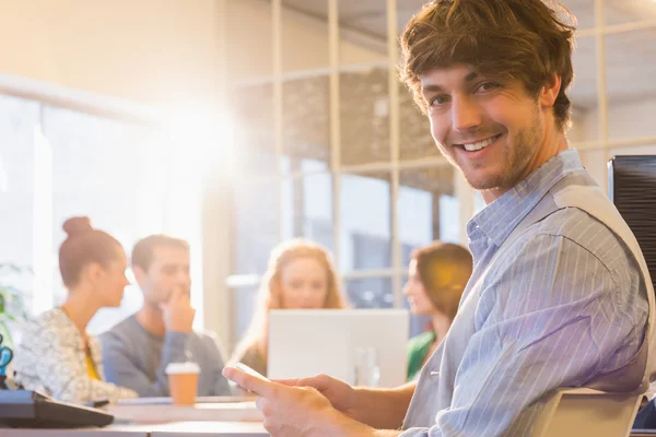 Portrait of smiling young businessman with colleagues — Stock Photo, Image